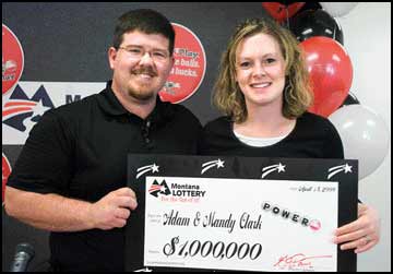 Adam and Mandy Clark of East Missoula hold their $1 million Powerball prize during a press conference at the Montana Lottery headquarters in Helena on Friday.